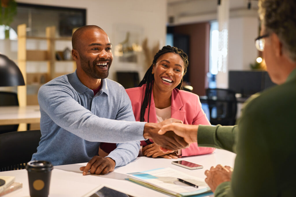Sales professionals shaking hands with a customer, demonstrating customer engagement.